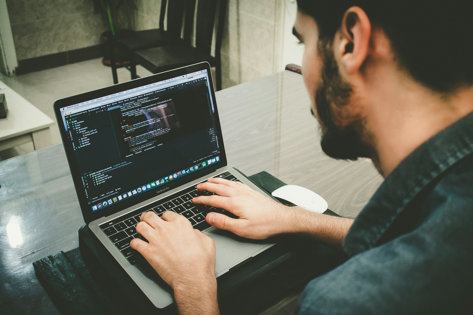 A developer writing code on a laptop late in the day