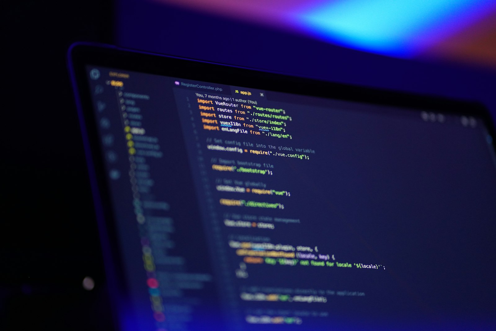 A code editor glowing on a laptop screen in a dark room