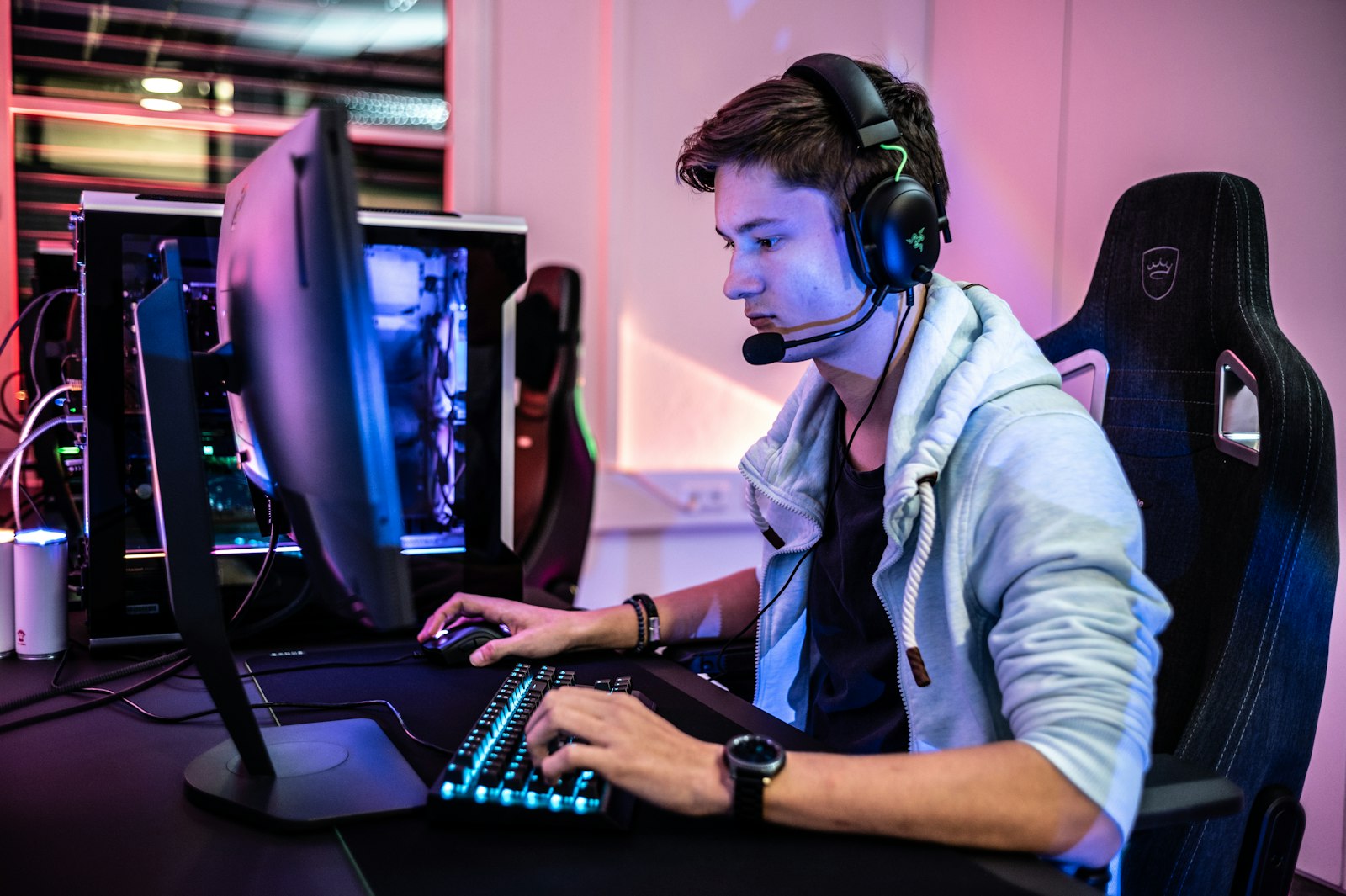 A streamer wearing a headset, live at a two-monitor setup
