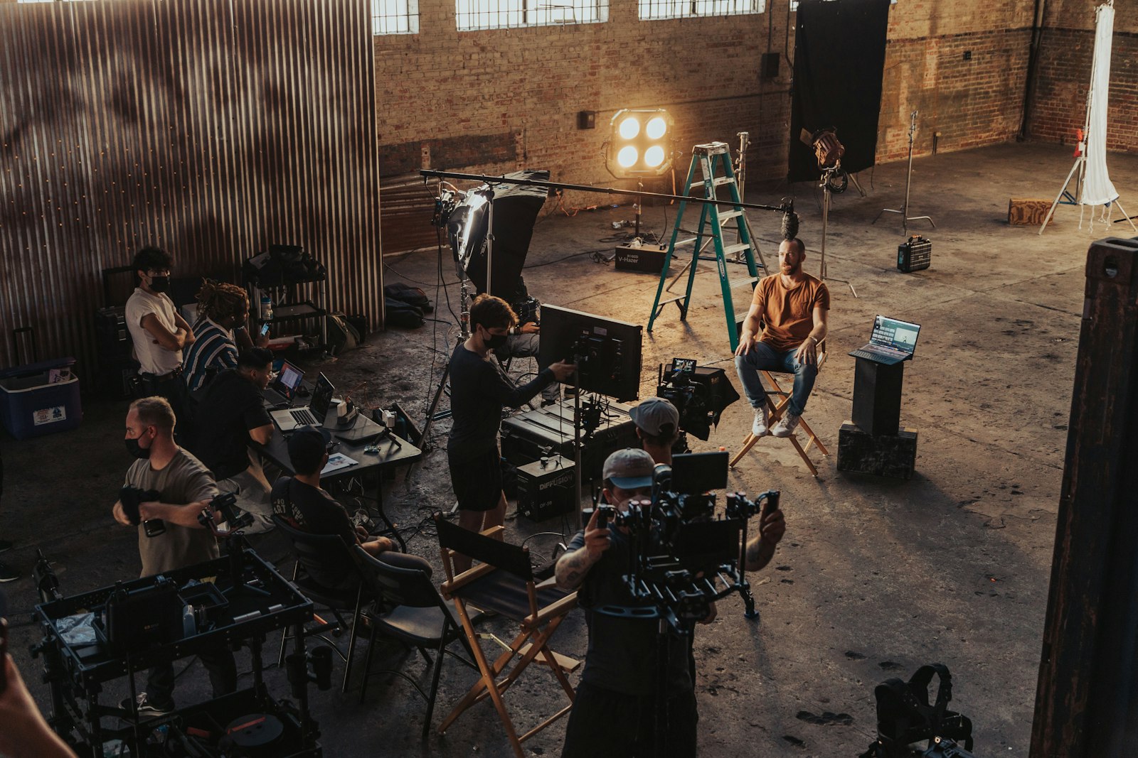 A film crew shooting an interview on a warehouse set in warm light